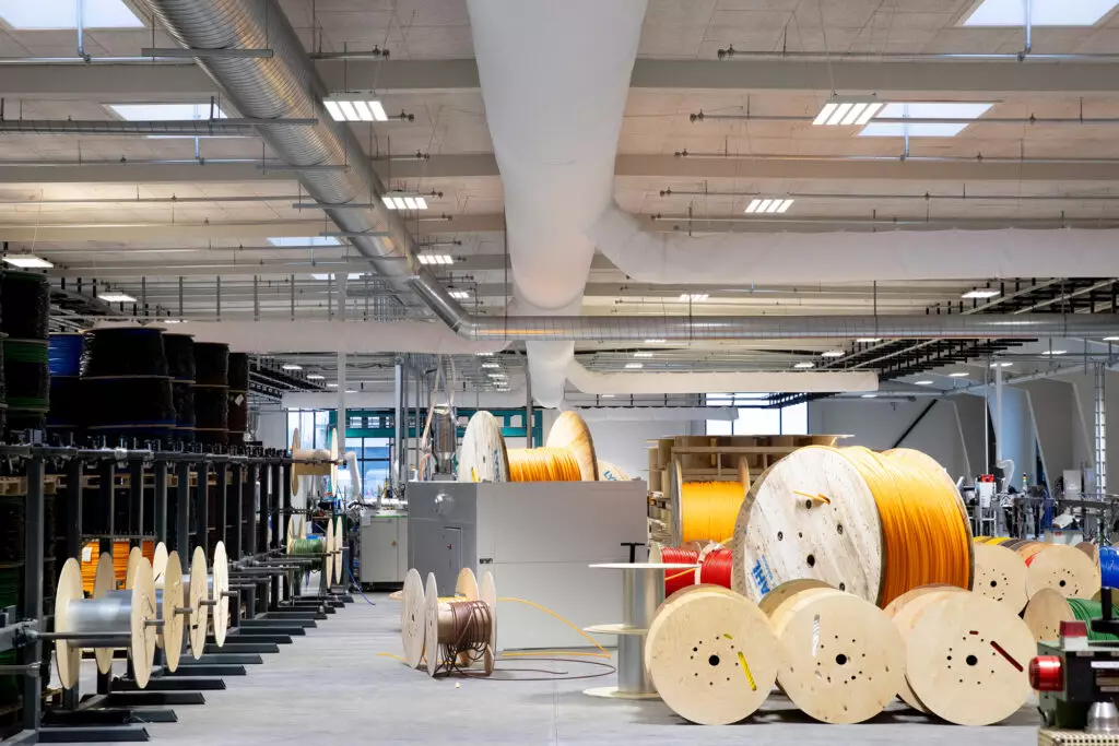 Weiße FabricAir-Textilschläuche zur Luftverteilung unter der Decke einer Produktionshalle